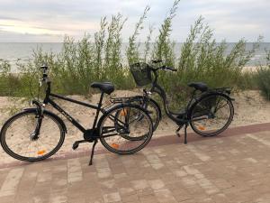 zwei Fahrräder stehen neben dem Strand geparkt in der Unterkunft Apartament z rowerami in Misdroy