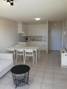 ein Wohnzimmer mit einem weißen Sofa und einem Tisch in der Unterkunft Bella Plaza in De Panne