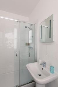 a white bathroom with a sink and a shower at The Queens St Ives in St Ives