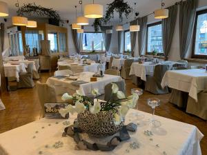 un comedor con mesas con manteles blancos en Hotel Col di Lana en Canazei