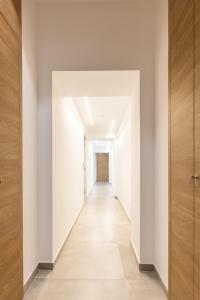 an empty hallway with white walls and a wooden door at Lux Caracciolo in Naples