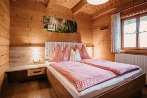 a bedroom with a bed in a wooden cabin at DAS "ZwisleggGut" in Wagrain