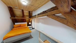 an attic bedroom with a bed and wooden ceilings at Karl V - Geschichte leben im Herzen der Altstadt in Schwäbisch Hall