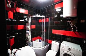 a red and black bathroom with a toilet and a washing machine at jako in Batumi +10 photos
