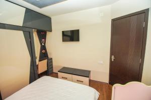 a bedroom with a bed and a desk and a tv at jako in Batumi