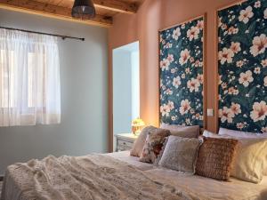 1 dormitorio con 1 cama con flores en la pared en Arbarosa Villa, en Agios Nikolaos