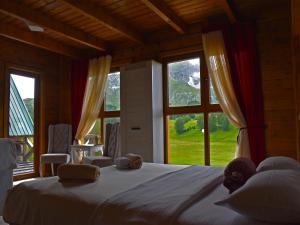 a bedroom with a large bed with a large window at Etno selo Sljeme in Žabljak
