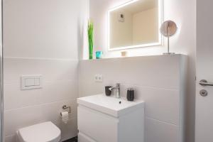 Un baño blanco con inodoro y lavabo. en Hafenspitze No1, en Heiligenhafen