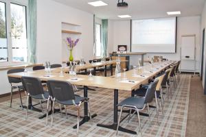uma grande sala de conferências com uma mesa longa e cadeiras em Hotel Zur Post em Ismaning