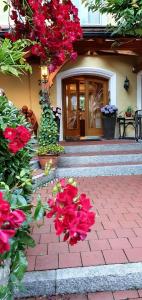 ein Haus mit roten Blumen vor einer Tür in der Unterkunft Hotel Cebulj in Bad Wörishofen