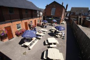 een patio met tafels en parasols bij The Angel in Wootton Bassett in Royal Wootton Bassett