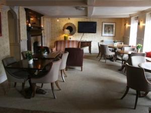 un restaurante con mesas, sillas y un piano en The Angel in Wootton Bassett en Royal Wootton Bassett