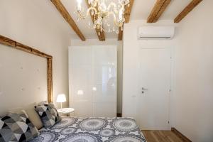una camera con letto e lampadario a braccio di la Maison de Trieste Suite garage a Trieste