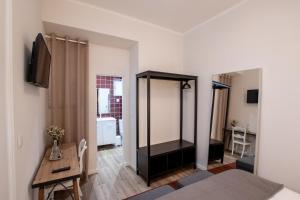 Habitación con cama, escritorio y espejo. en Carnot House en Setúbal