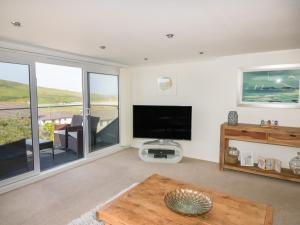 a living room with a television and a table at Atlantic View in Newquay