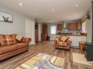 ein Wohnzimmer mit einem Sofa und Stühlen sowie eine Küche in der Unterkunft Park Brook Dell in Preston