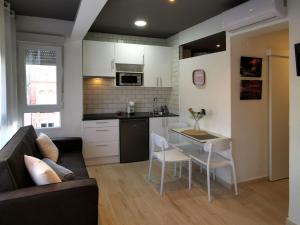 a kitchen and living room with a couch and a table at Estudios Placeta dels Bous - Plaza Constitución in Benicarló