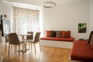 sala de estar con sofá, mesa y sillas en Casa das Aguarelas - Apartamentos, en Ericeira