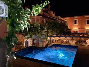 a large blue swimming pool in a yard at night at Relais 147 - Luxury b&b in Taormina