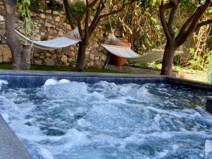 a hot tub with hammocks in a yard with trees at Relais 147 - Luxury b&b in Taormina
