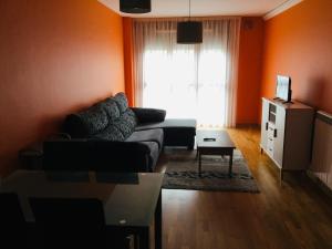 - un salon avec un canapé et une fenêtre dans l'établissement Apartamento Rio Barayo, à Luarca