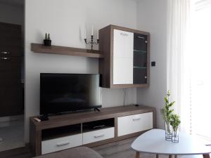 a living room with a television and a table at Apartmani Ponistra in Šibenik