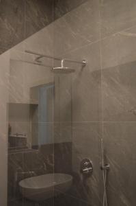 bagno con doccia e porta in vetro di Camere Scandellara 24 a Bologna