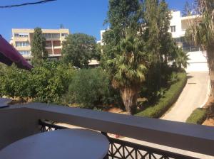 a balcony with a view of a street and trees at Rethymno Blue Apartments in Rethymno