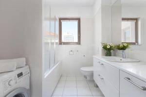 a white bathroom with a toilet and a sink at Elite Apartments Waterlane Swimming Pool&aSpa in Gdańsk