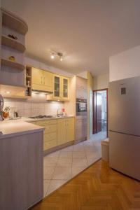 cocina con armarios amarillos y nevera blanca en Sun & More Apartment, en Crikvenica