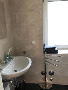 baño con lavabo blanco y ventana en Haus Sonnenschein en Timmendorfer Strand