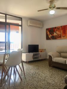 een woonkamer met een tafel en een televisie bij Apartamento San Juan Bosco in Almería