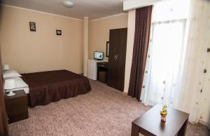 una habitación de hotel con una cama y un escritorio en Vila KM 0, en Neptun