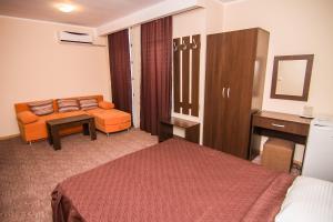 Una habitación de hotel con una cama, un sofá y una mesa. en Vila KM 0, en Neptun 2 fotos más