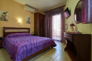 a bedroom with a purple bed and a window at Fotini House in Sarti