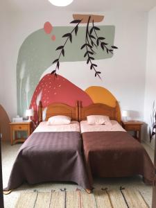 a bedroom with a bed, a chair, and a painting on the wall at joyhouse in Teguise