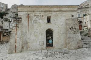 een oud gebouw met een blauwe vaas in een raam bij Pietragialla in Matera