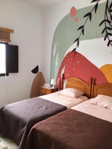 a bedroom with a bed and a painting on the wall at joyhouse in Teguise