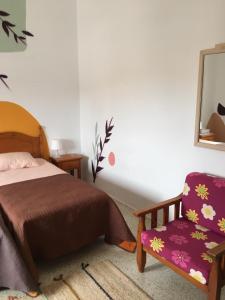 a bedroom with a bed, desk, chair and lamp at joyhouse in Teguise