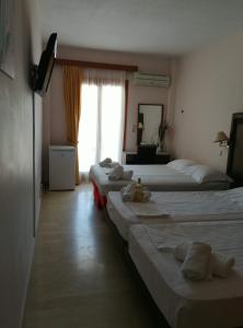 fila de camas en una habitación de hotel en Verdelis Inn, en Palaia Epidavros