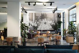 a restaurant with tables and chairs and a painting of a meeting at The Gem Society Hotel in Athens