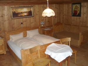 ein Schlafzimmer mit einem Bett in einem Zimmer mit Holzwänden in der Unterkunft Haus Schellenschmied in Pettneu am Arlberg