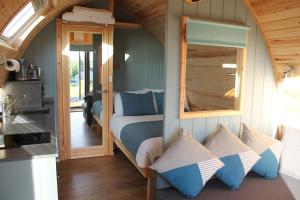 a bedroom with a bed with a mirror and pillows at North Star Glamping in Lybster