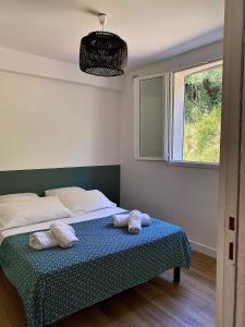 um quarto com uma cama com duas almofadas em Propriété Malva appartement bergamotta em Alata