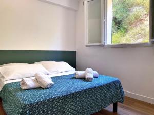 1 cama con 2 almohadas en una mesa con ventana en Propriété Malva appartement bergamotta, en Alata