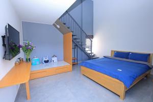 ein Schlafzimmer mit einem blauen Bett und einer Treppe in der Unterkunft Maison de Fleurs - Ngôi Nhà Hoa in Da Lat