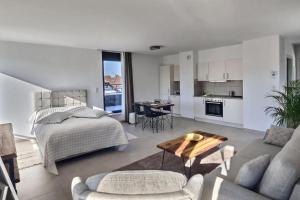 een slaapkamer en een woonkamer met een bed en een tafel bij KRésidence - Appartements Saint-Louis in Saint-Louis