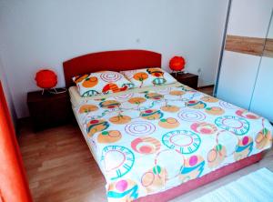a bedroom with a bed with a colorful bedspread at Apartman Hortensie in Palit