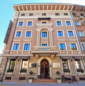 a large pink building with a balcony at Hotel Antique - free private parking in Plovdiv