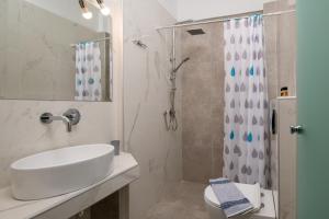 a white bathroom with a sink and a shower at Fantasia Studios and Apartments in Neos Marmaras +169 photos
